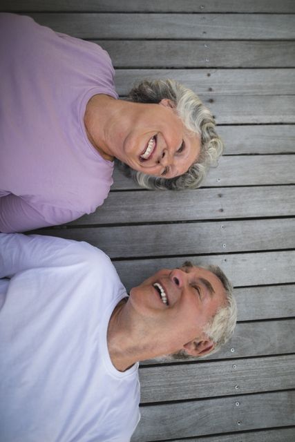 Overhead view of happy senior couple lying on wooden floor - Download Free Stock Photos Pikwizard.com