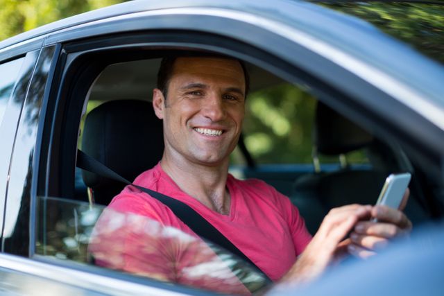 Portrait of smiling man using mobile phone in car - Download Free Stock Photos Pikwizard.com