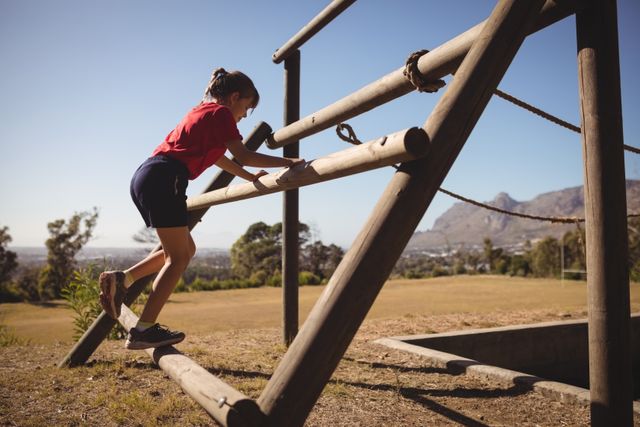 Girl exercising on outdoor equipment during obstacle course - Download Free Stock Photos Pikwizard.com