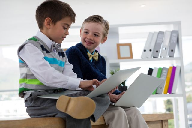 Kids as business executives using laptop while sitting on table - Download Free Stock Photos Pikwizard.com