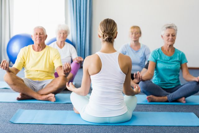 Instructor performing yoga with seniors - Download Free Stock Photos Pikwizard.com