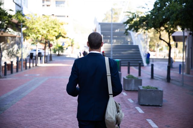 Rear view of Caucasian businessman walking down the street  - Download Free Stock Photos Pikwizard.com