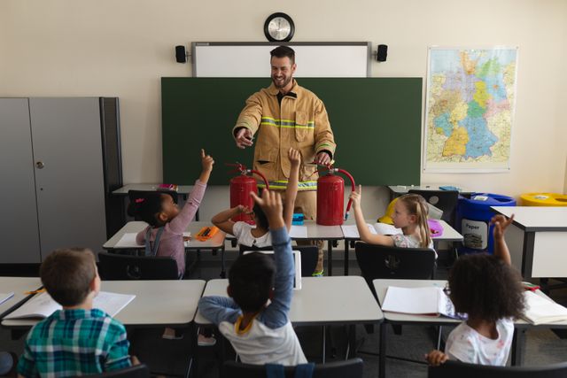Schoolkids raising hands while male firefighter teaching about fire safety in classroom - Download Free Stock Photos Pikwizard.com