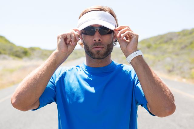 Male athlete wearing sunglasses on road - Download Free Stock Photos Pikwizard.com