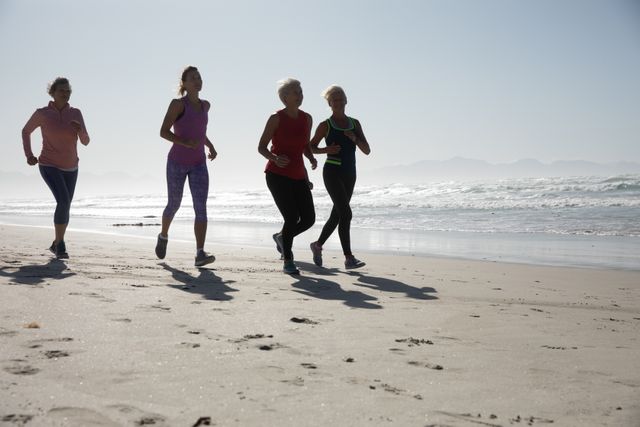 Group of woman running on the beach - Download Free Stock Photos Pikwizard.com