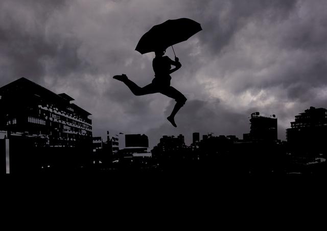 Digitally generated image of man silhouette holding an umbrella against cityscape