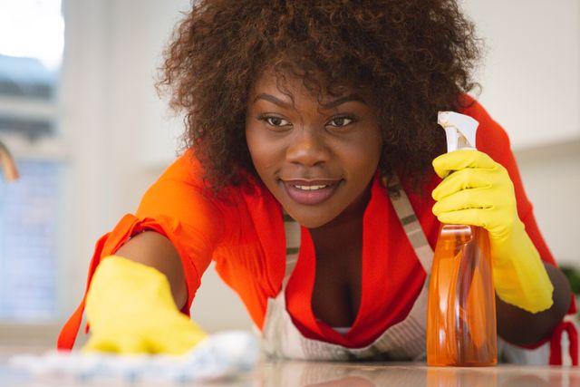 African american female wearing gloves, cleaning kitchen worktop - Download Free Stock Photos Pikwizard.com