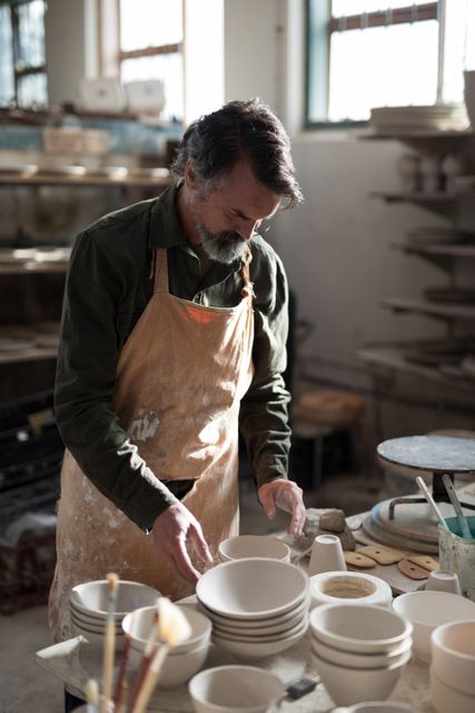 Male potter working at worktop in pottery workshop