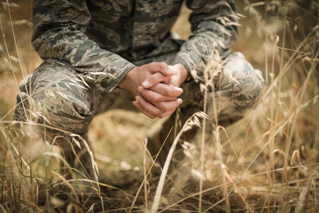 Military soldier crouching in grass - Download Free Stock Photos Pikwizard.com