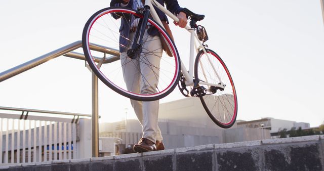 Asian man carrying bicycle while walking down the stairs at corporate park. business and lifestyle concept