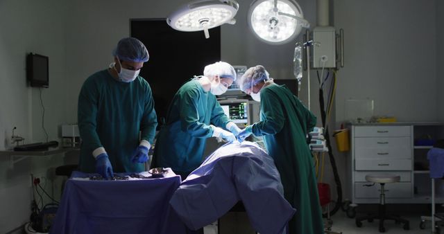 Image of diverse male assistant and female surgeons operating on patient in operating theatre. Hospital, medical and healthcare services.
