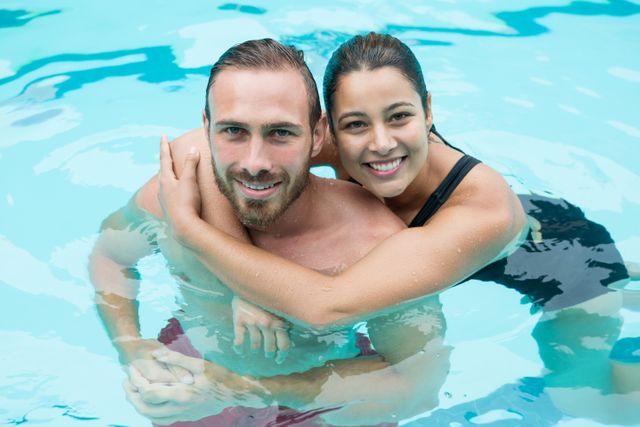 Smiling couple embracing in swimming pool - Download Free Stock Photos Pikwizard.com