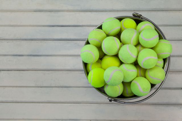 Overhead view of tennis balls in metallic bucket - Download Free Stock Photos Pikwizard.com