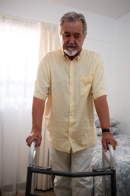 Senior man walking with walker at nursing home - Download Free Stock Photos Pikwizard.com