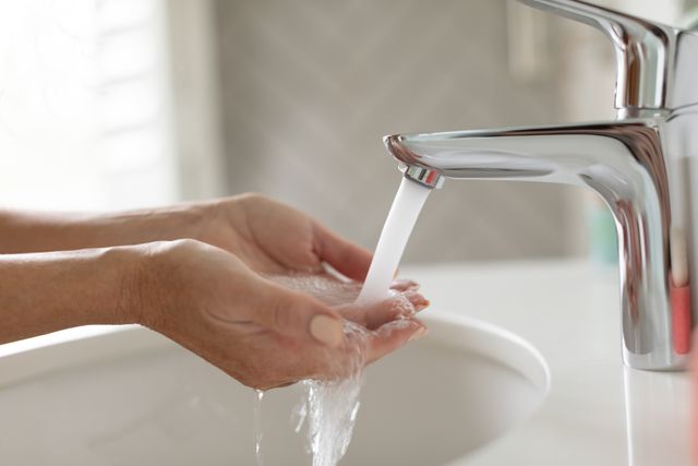 Woman washing her hands in washbasin in bathroom - Download Free Stock Photos Pikwizard.com