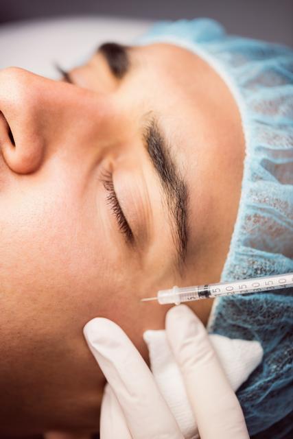 Man receiving botox injection on his face at clinic