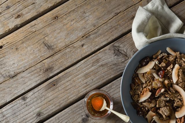 Healthy breakfast in bowl and honey on a wooden table - Download Free Stock Photos Pikwizard.com