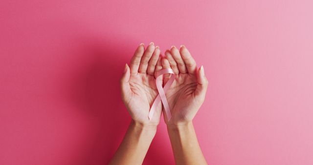 Image of hands of caucasian woman holding pink ribbon on pink background - Download Free Stock Photos Pikwizard.com