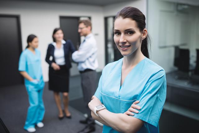 Smiling nurse standing with arms crossed - Download Free Stock Photos Pikwizard.com