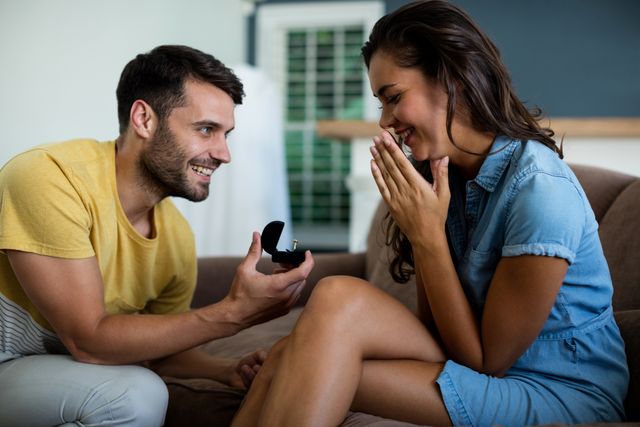 Man offering a engagement ring to woman in the living room - Download Free Stock Photos Pikwizard.com