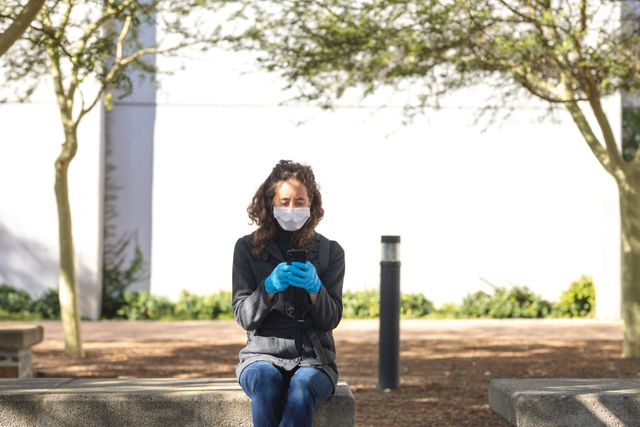 Woman wearing face mask and gloves using smartphone - Download Free Stock Photos Pikwizard.com