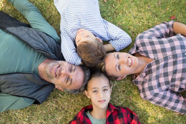 Happy family lying on the grass - Download Free Stock Photos Pikwizard.com