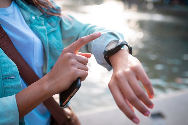 Hands of asian woman holding smartphone and checking smartwatch in street - Download Free Stock Photos Pikwizard.com