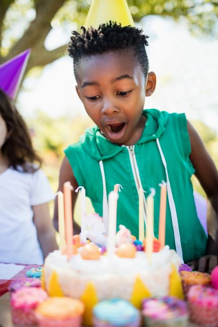 Portrait of cute boy preparing to blow on candle during a birthday party - Download Free Stock Photos Pikwizard.com