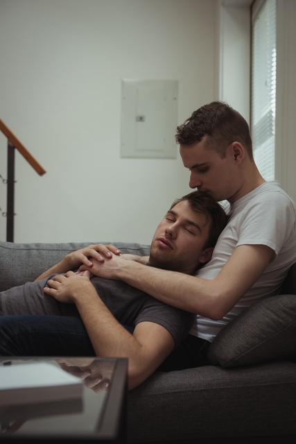 Romantic gay couple relaxing on sofa in living room - Download Free Stock Photos Pikwizard.com