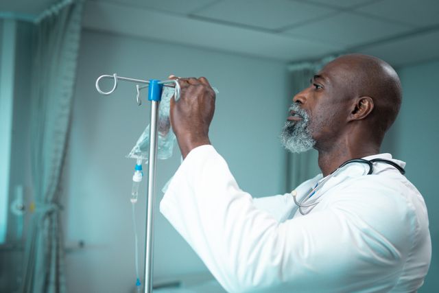 African american male doctor putting drip on tripod in hospital room - Download Free Stock Photos Pikwizard.com