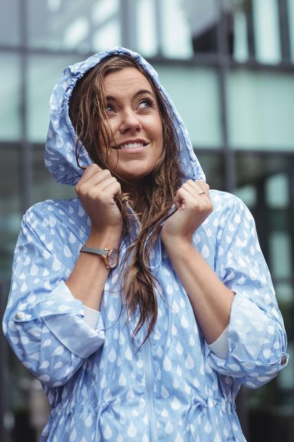 Thoughtful beautiful woman wearing windcheater during rainy season