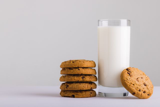 Milk glass with stack of cookies against white background, copy space - Download Free Stock Photos Pikwizard.com