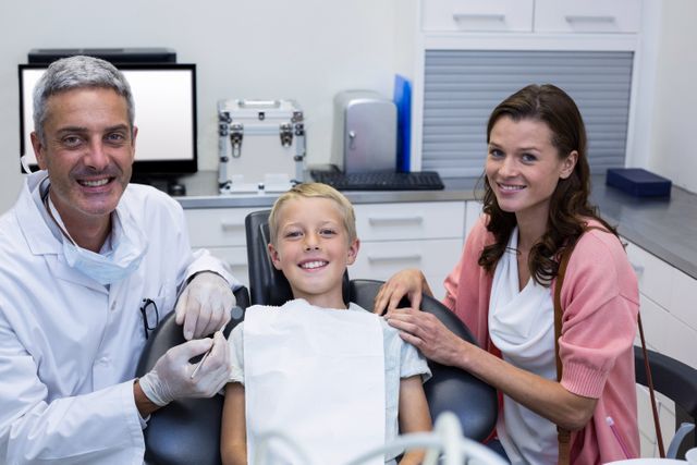 Portrait of dentist with young patient and his mother - Download Free Stock Photos Pikwizard.com