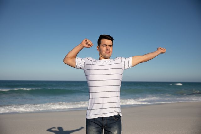 Man stretching his arms at the beach - Download Free Stock Photos Pikwizard.com