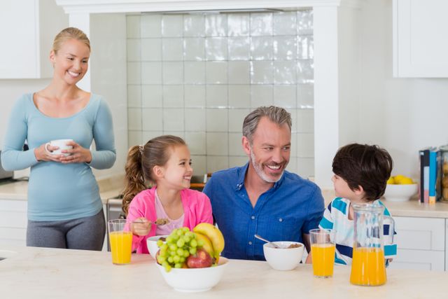 Happy family having breakfast in kitchen - Download Free Stock Photos Pikwizard.com