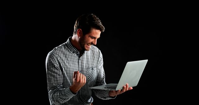 A young Caucasian man expresses excitement while looking at his laptop, with copy space - Download Free Stock Photos Pikwizard.com