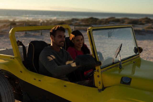 Happy caucasian couple driving in beach buggy by the sea at sunset, smiling - Download Free Stock Photos Pikwizard.com