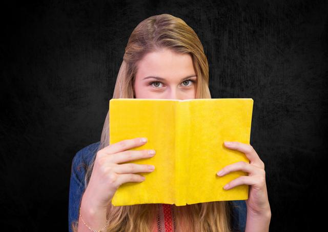 Woman holding a book against black background - Download Free Stock Photos Pikwizard.com