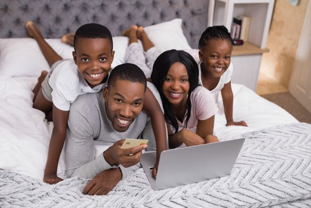 Portrait of happy family shopping online on bed - Download Free Stock Photos Pikwizard.com