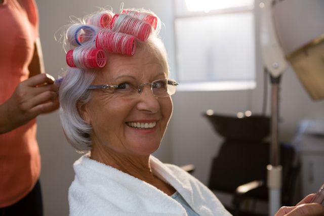 Cropped hands of hairstylist removing curlers from smiling woman hair - Download Free Stock Photos Pikwizard.com