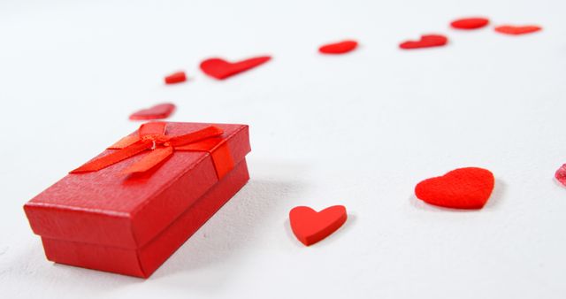 Red gift box and red hearts on white surface - Download Free Stock Photos Pikwizard.com