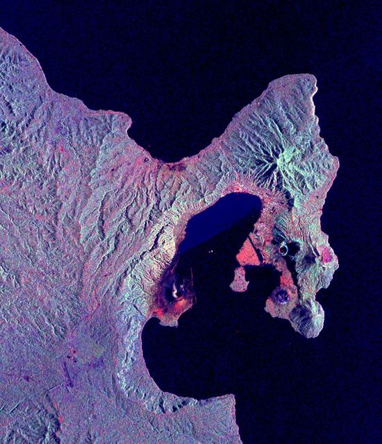 This is a radar image of the Rabaul volcano on the island of New Britain, Papua, New Guinea taken almost a month after its September 19, 1994, eruption that killed five people and covered the town of Rabaul and nearby villages with up to 75 centimeters (30 inches) of ash. More than 53,000 people have been displaced by the eruption.  The image was acquired by the Spaceborne Imaging Radar-C/X-band Synthetic Aperture Radar (SIR-C/X-SAR) aboard the space shuttle Endeavour on its 173rd orbit on October 11, 1994. This image is centered at 4.2 degrees south latitude and 152.2 degrees east longitude in the southwest Pacific Ocean. The area shown is approximately 21 kilometers by 25 kilometers (13 miles by 15.5 miles). North is toward the upper right. The colors in this image were obtained using the following radar channels: red represents the L-band (horizontally transmitted and received); green represents the L-band (horizontally transmitted and vertically received); blue represents the C-band (horizontally transmitted and vertically received).  Most of the Rabaul volcano is underwater and the caldera (crater) creates Blanche Bay, the semi-circular body of water that occupies most of the center of the image. Volcanic vents within the caldera are visible in the image and include Vulcan, on a peninsula on the west side of the bay, and Rabalanakaia and Tavurvur (the circular purple feature near the mouth of the bay) on the east side. Both Vulcan and Tavurvur were active during the 1994 eruption. Ash deposits appear red-orange on the image, and are most prominent on the south flanks of Vulcan and north and northwest of Tavurvur. A faint blue patch in the water in the center of the image is a large raft of floating pumice fragments that were ejected from Vulcan during the eruption and clog the inner bay. Visible on the east side of the bay are the grid-like patterns of the streets of Rabaul and an airstrip, which appears as a dark northwest-trending band at the right-center of the image. Ashfall and subsequent rains caused the collapse of most buildings in the town of Rabaul. Mudflows and flooding continue to pose serious threats to the town and surrounding villages. Volcanologists and local authorities expect to use data such as this radar image to assist them in identifying the mechanisms of the eruption and future hazardous conditions that may be associated with the vigorously active volcano.  http://photojournal.jpl.nasa.gov/catalog/PIA01767