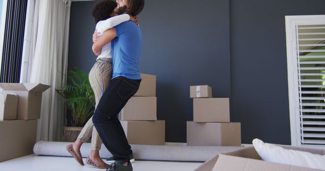 Mixed race couple dancing together in between cardboard boxes at new apartment house - Download Free Stock Photos Pikwizard.com