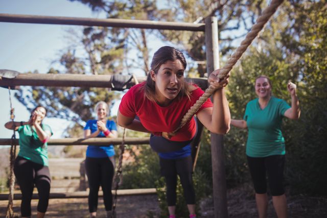 Fit woman climbing a rope during obstacle course training - Download Free Stock Photos Pikwizard.com