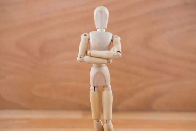 Wooden figurine standing with arms crossed - Download Free Stock Photos Pikwizard.com