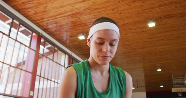 Caucasian female basketball player dribbling and shooting ball. basketball, sports training at an indoor court.