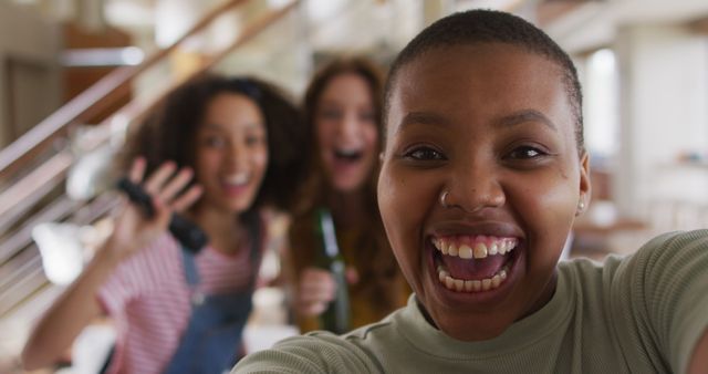 Diverse group of female friends having fun taking selfie singing karaoke and drinking beer at home - Download Free Stock Photos Pikwizard.com