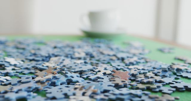 Image of puzzles and cups of coffee on green table. Retirement lifestyle, spending time together,active leisure time.