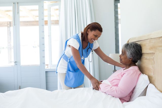 Female doctor comforting senior woman on bed - Download Free Stock Photos Pikwizard.com