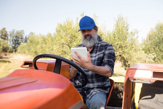 Man using digital tablet in tractor - Download Free Stock Photos Pikwizard.com